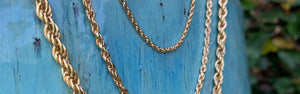 Three sizes of Inch of Gold rope chains on blue background